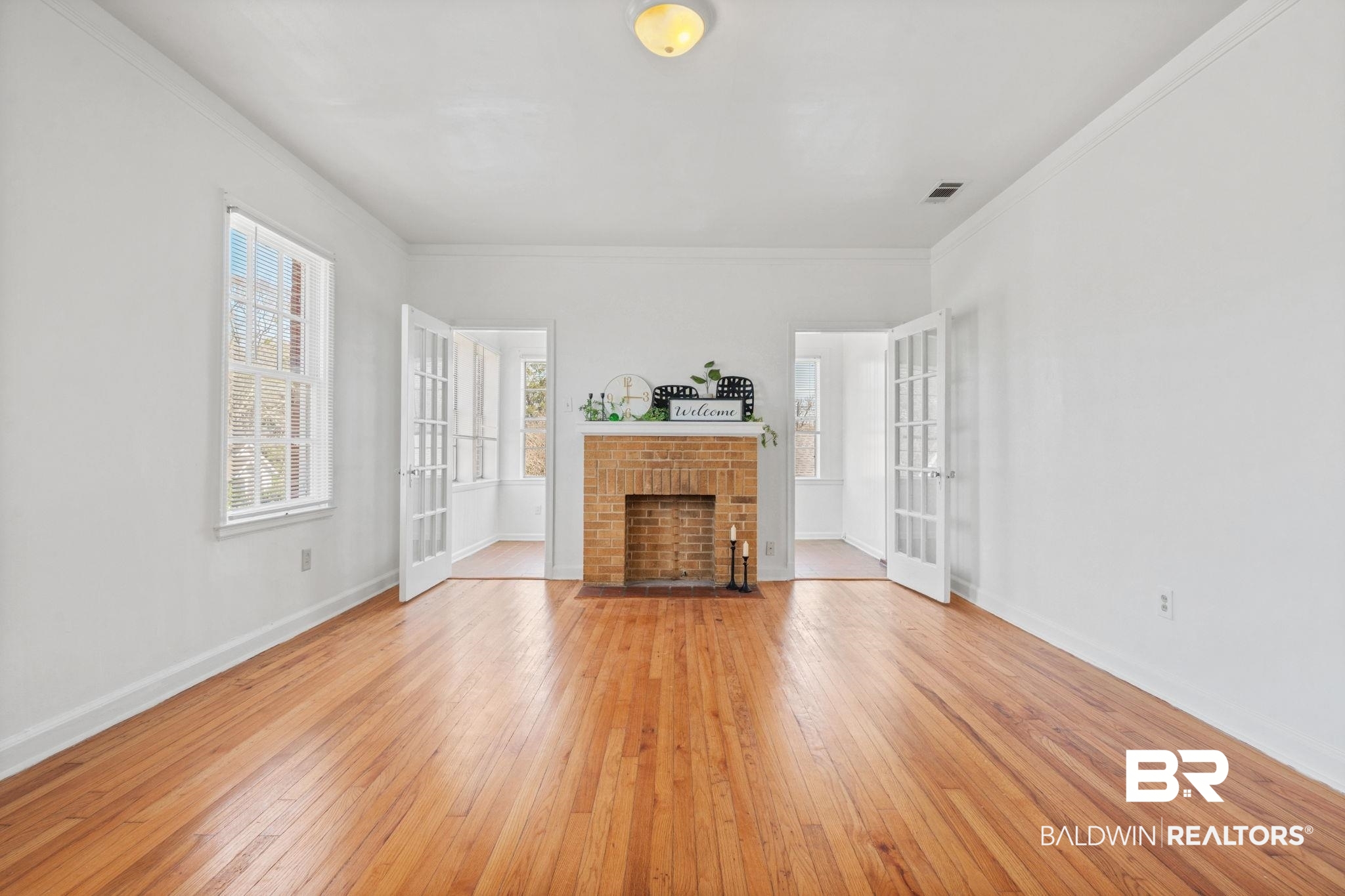 1707 Church Street Mobile, AL 36604 - Photo 19 of 43 Unfurnished living room with french doors, a fireplace, and light wood-type flooring