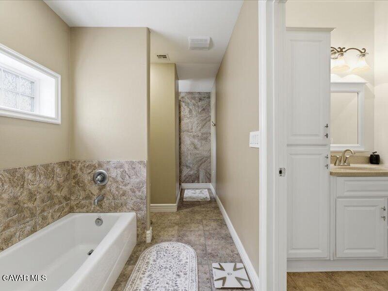 4107 Paddock Way Lancaster, CA 93536 - Photo 21 of 49 a bathroom with a bathtub and a shower