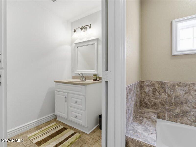 4107 Paddock Way Lancaster, CA 93536 - Photo 25 of 49 a bathroom with a granite countertop sink and a mirror