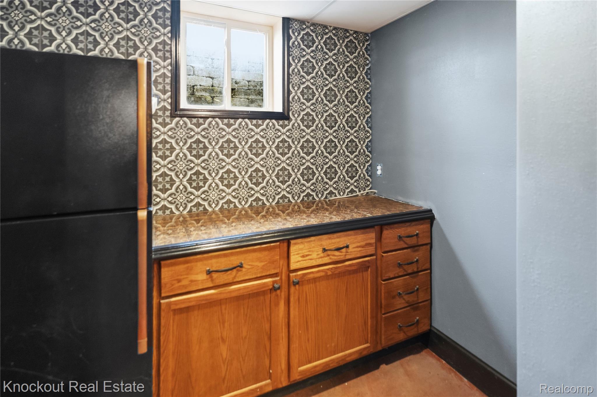 5750 Maple Road Frankenmuth, MI 48734 - Photo 42 of 60 Wood-finish cabinetry with dark hardware, complemented by a patterned wall covering