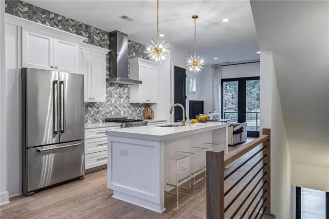 a kitchen with stainless steel appliances a refrigerator and a chandelier