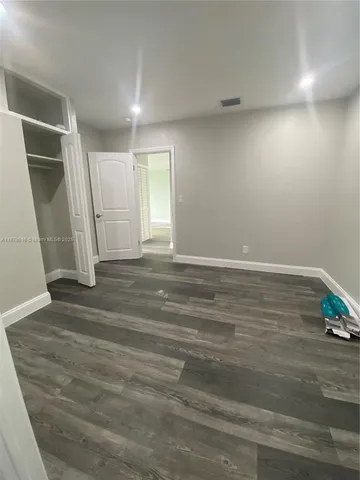 an empty room with wooden floor and window