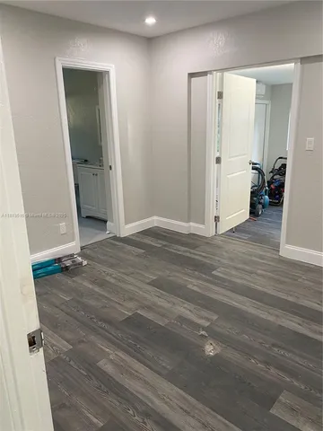 an empty room with wooden floor and mirror