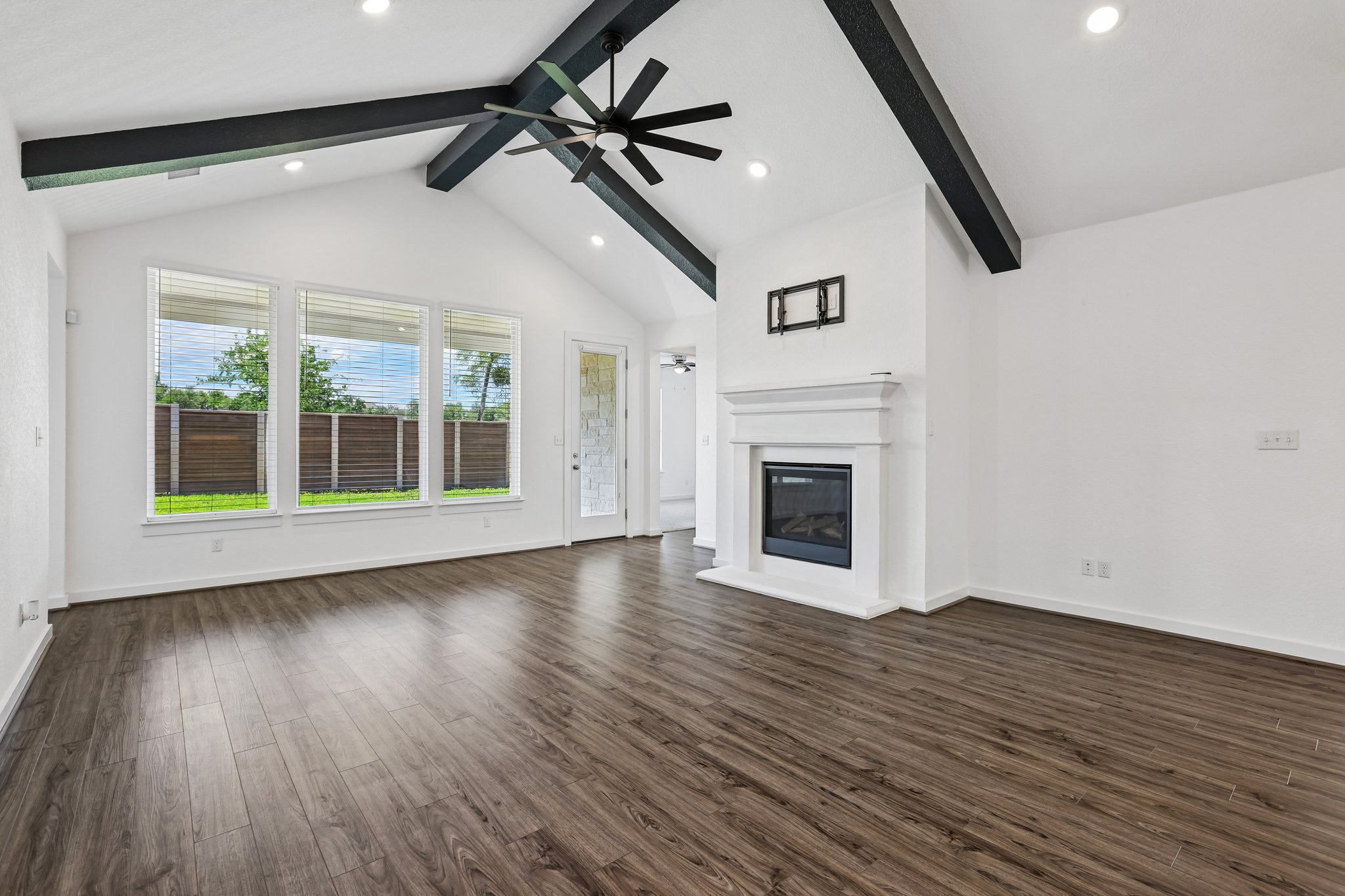 317 Independence Drive Kyle, TX 78640 - Photo 12 of 40 a view of an empty room with wooden floor fireplace and a window
