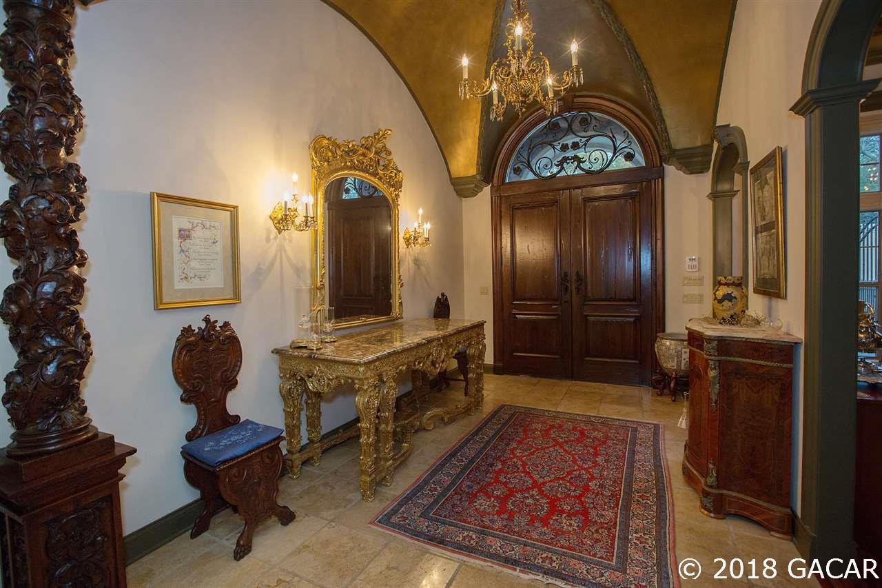 4626 Southwest 97th Terrace Gainesville, FL 32608 - Photo 2 of 30 Breathtaking foyer with majestic front entry doors with handles hand forged in Brazil, faux painted vaulted ceilings, and hand carved wood columns imported from a Tuscan villa.