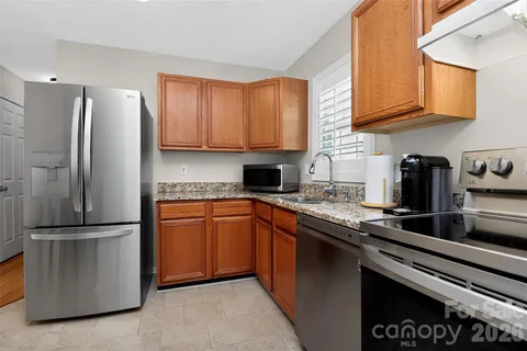 a kitchen with stainless steel appliances granite countertop a refrigerator sink and stove