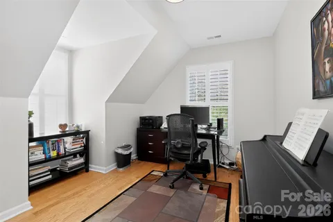 a view of a workspace with furniture and wooden floor