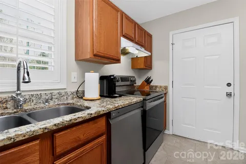 a kitchen with stainless steel appliances granite countertop a sink stove and cabinets