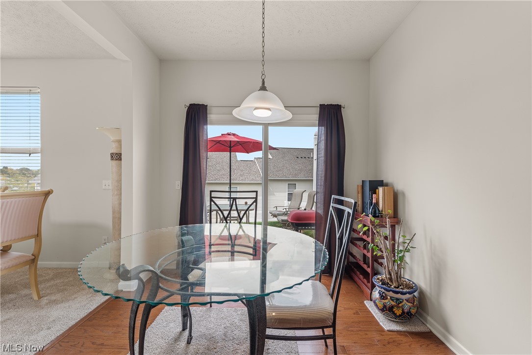 3967 Gardiner Run Akron, OH 44321 - Photo 7 of 35 Dining space featuring light hardwood floors and a textured ceiling