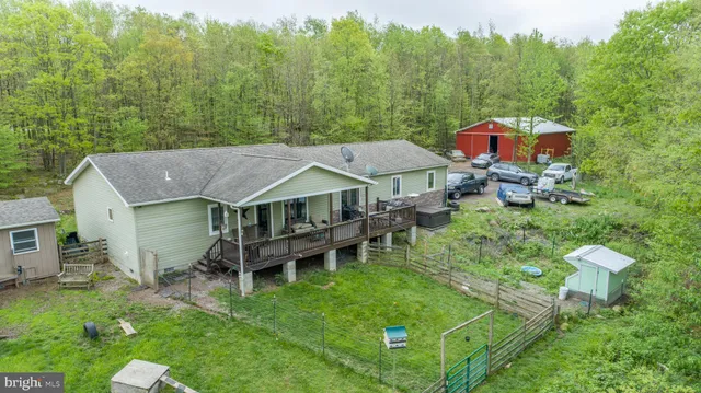 an aerial view of a house with swimming pool garden view and trees