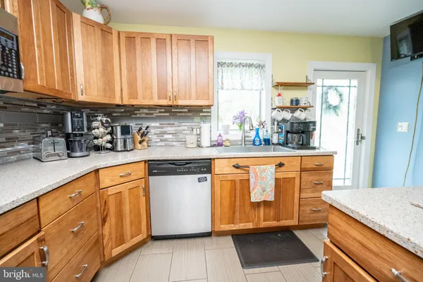 a kitchen with stainless steel appliances granite countertop a sink dishwasher a stove refrigerator and microwave