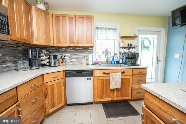 a kitchen with stainless steel appliances granite countertop a sink dishwasher a stove refrigerator and microwave
