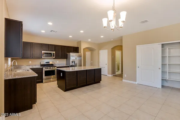 a kitchen with kitchen island granite countertop a sink counter top space and stainless steel appliances