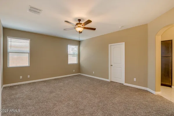 an empty room with a ceiling fan and a bathroom