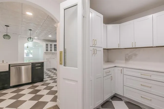 a kitchen with white cabinets and stainless steel appliances