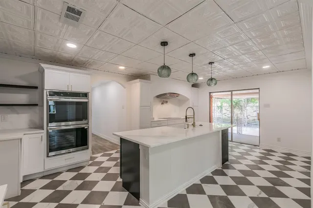 a large kitchen with a sink and stainless steel appliances