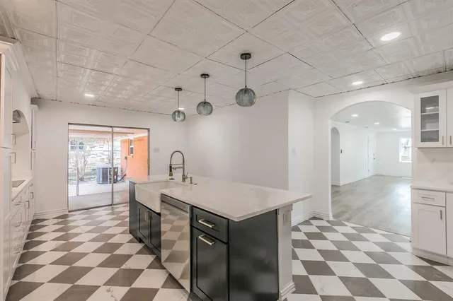 a large white kitchen with a stove a sink and a refrigerator