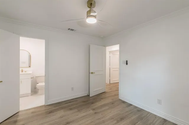 wooden floor in an empty room with a bathroom