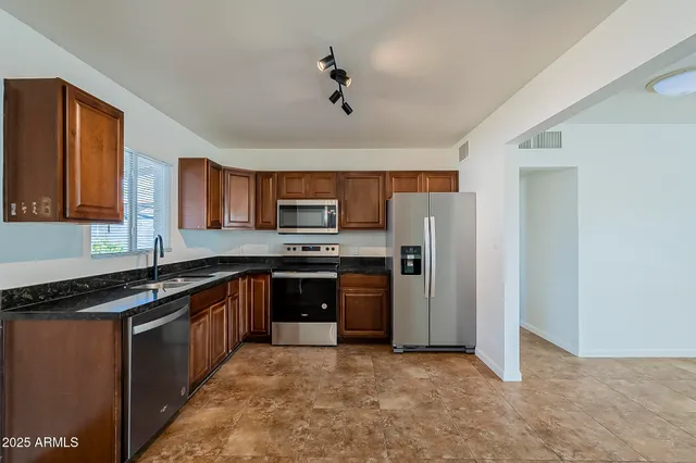 a kitchen with stainless steel appliances granite countertop a stove sink and refrigerator