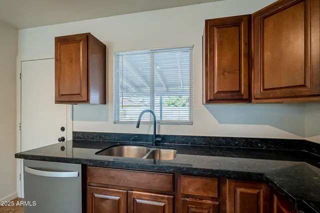 a kitchen with granite countertop cabinets sink and window