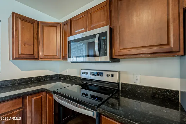 a kitchen with wooden cabinets and a stove top oven