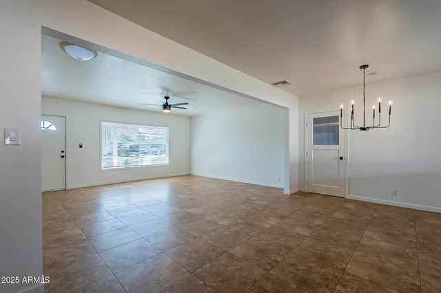an empty room with windows and fireplace