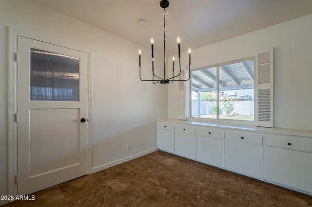 a view of empty room with wooden floor and window