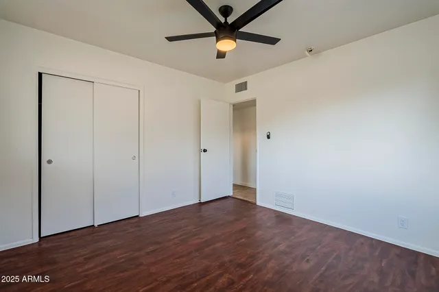 a view of a room with wooden floor and a ceiling fan