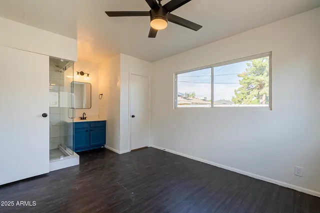 a view of an empty room with window and wooden floor