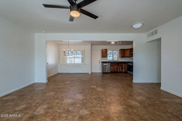 an empty room with windows and cabinet
