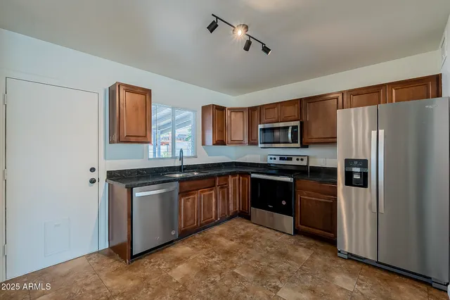 a kitchen with granite countertop stainless steel appliances and wooden cabinets