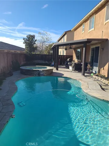 a view of a house with swimming pool and sitting area