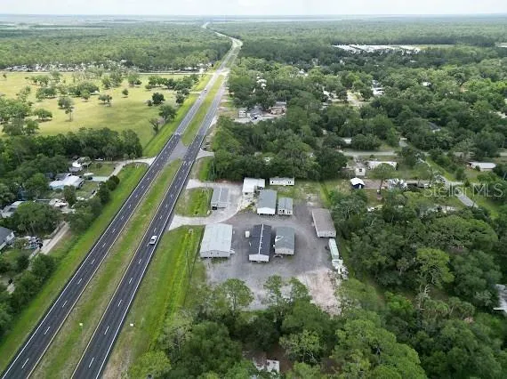 an aerial view of residential houses with outdoor space and trees
