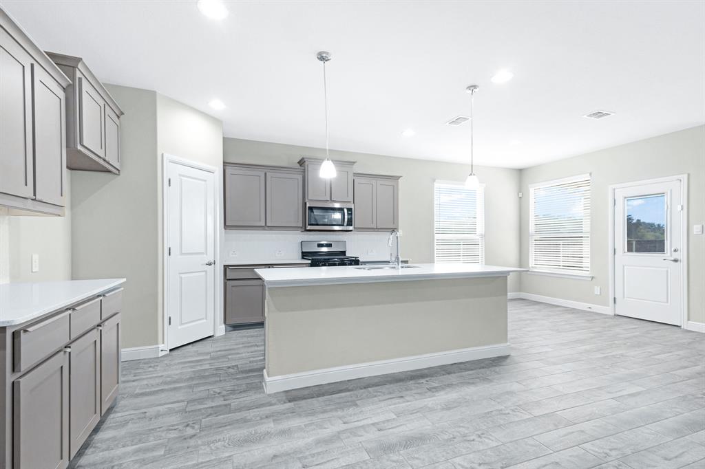 15501 Balham Path Fort Worth, TX 76247 - Photo 3 of 22 a large kitchen with cabinets wooden floor and stainless steel appliances
