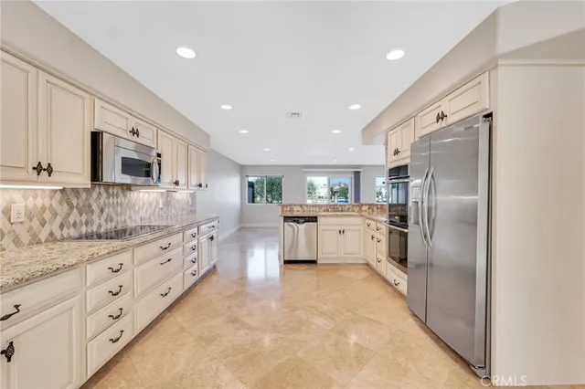 a large kitchen with cabinets stainless steel appliances and window