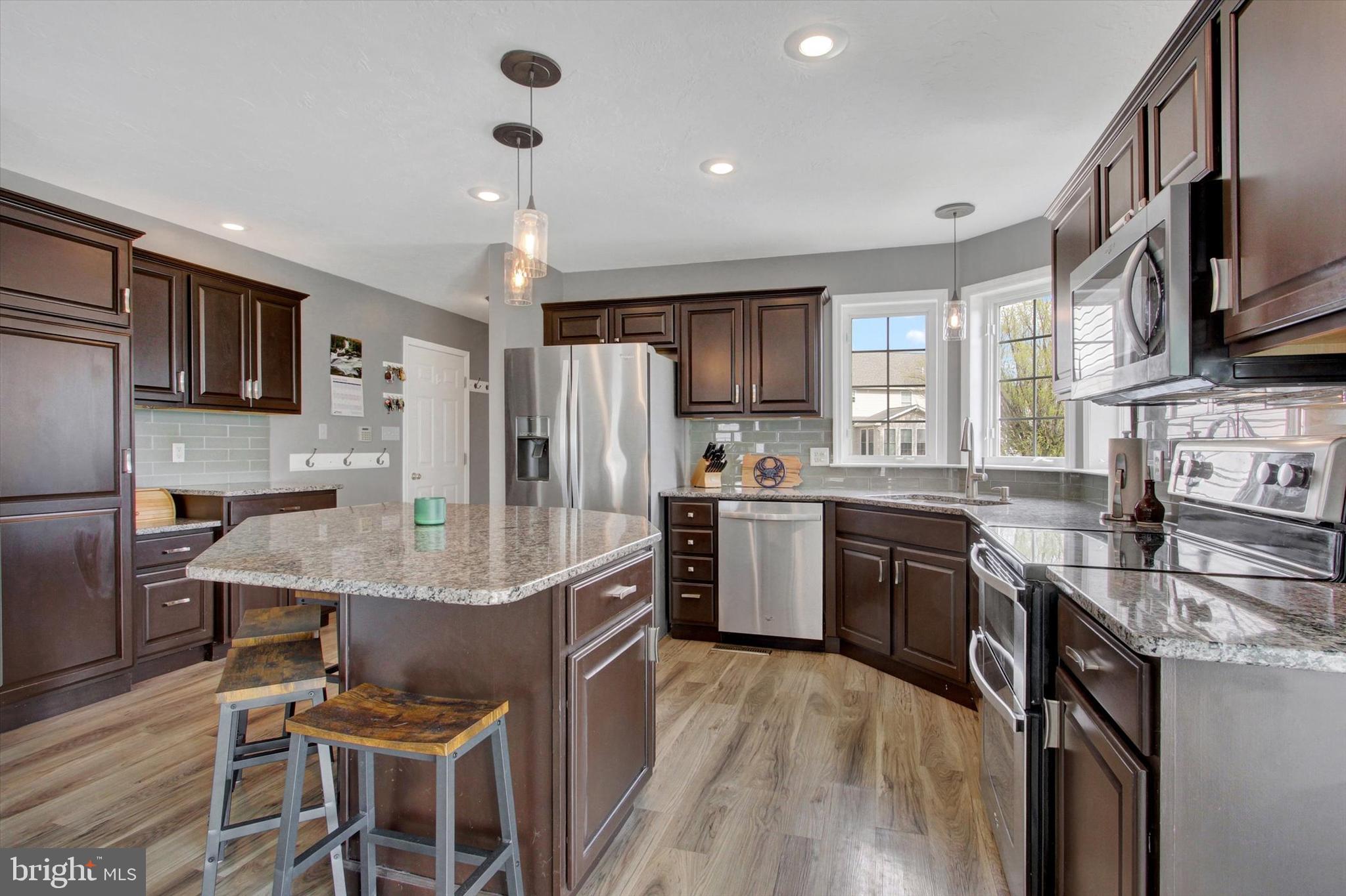 5010 Grandview Road Hanover, PA 17331 - Photo 12 of 42 a kitchen with stainless steel appliances granite countertop a refrigerator a stove top oven a sink dishwasher and white cabinets with wooden floor
