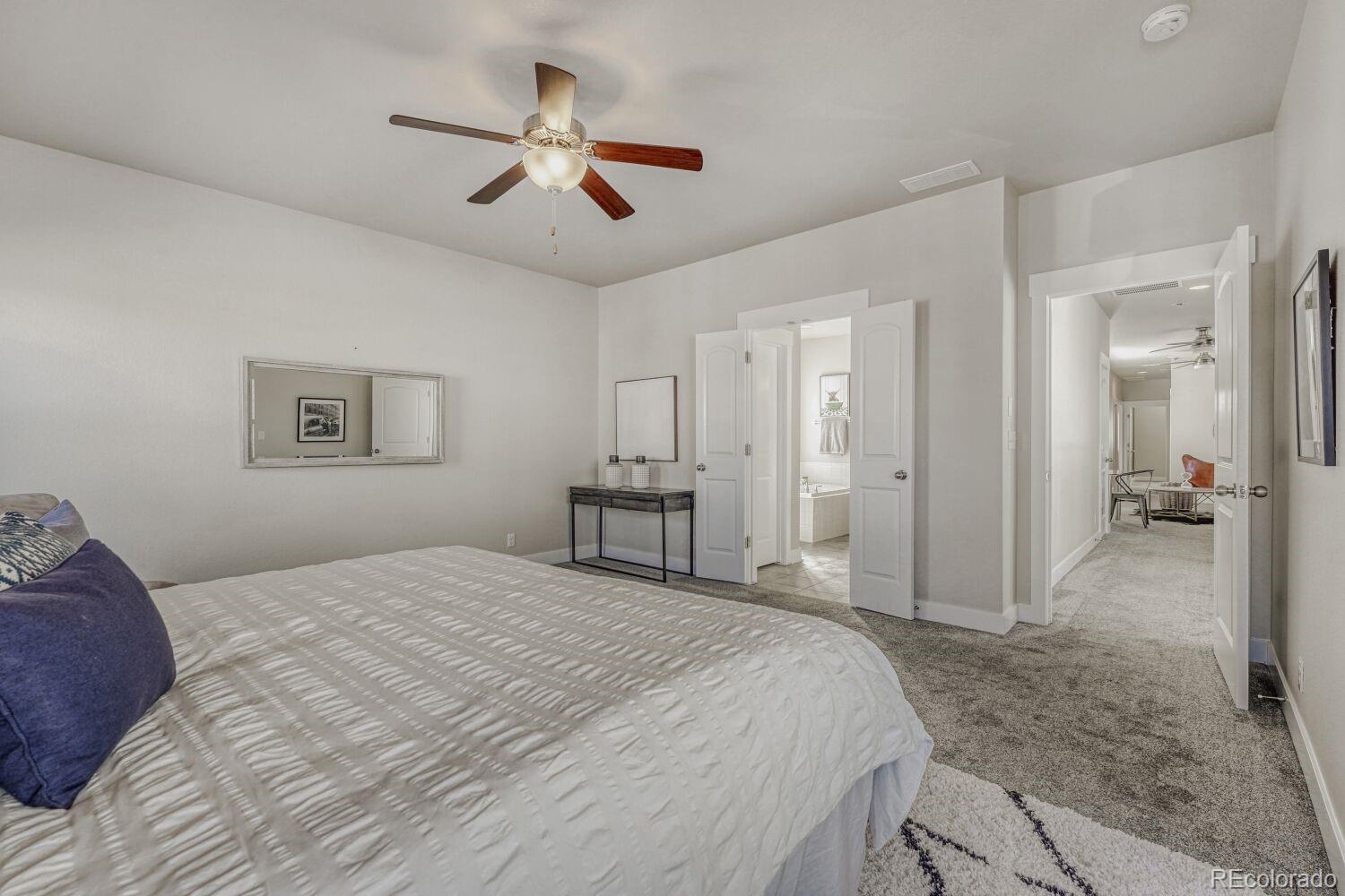 2861 Lima Street Denver, CO 80238 - Photo 18 of 45 a bedroom with a large bed and a chandelier