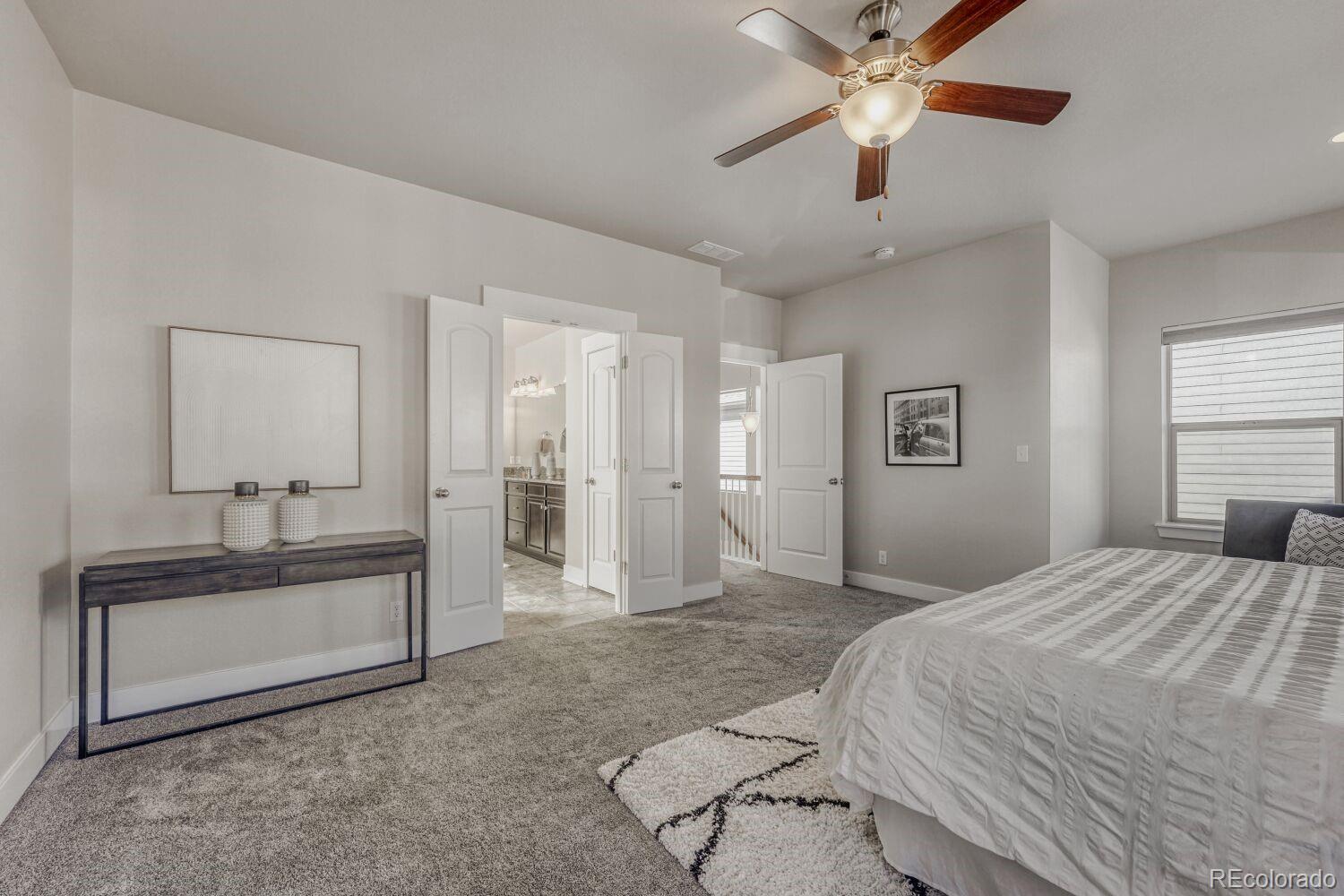 2861 Lima Street Denver, CO 80238 - Photo 19 of 45 a spacious bedroom with a bed and a chandelier