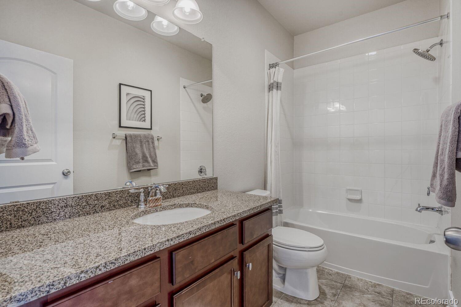 2861 Lima Street Denver, CO 80238 - Photo 27 of 45 a bathroom with a granite countertop sink toilet and shower
