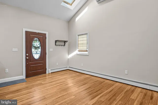 an empty room with wooden floor cabinet and windows