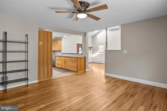 a view of a kitchen with wooden floor and a ceiling fan