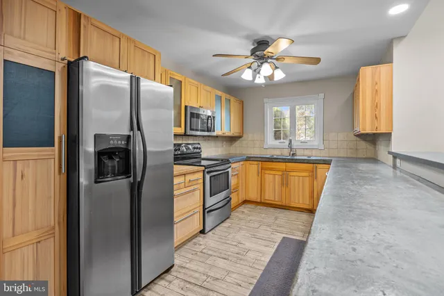 a kitchen with granite countertop a refrigerator and a sink