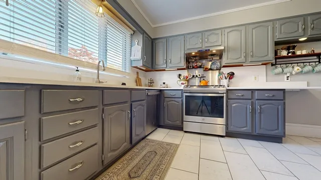 a large kitchen with stainless steel appliances granite countertop a sink stove and cabinets