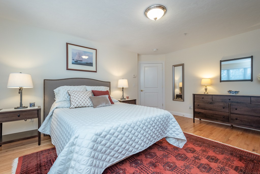 1094 Hill Road, Unit 1094 Boxborough, MA 01719 - Photo 21 of 38 a bedroom with a bed and a lamp on dresser