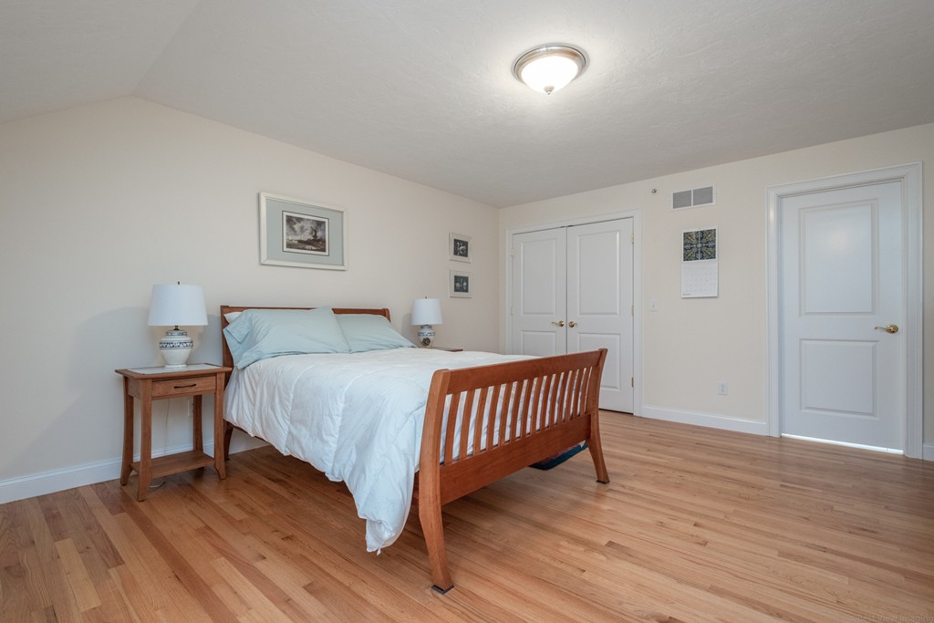 1094 Hill Road, Unit 1094 Boxborough, MA 01719 - Photo 29 of 38 a bedroom with a bed and wooden floor
