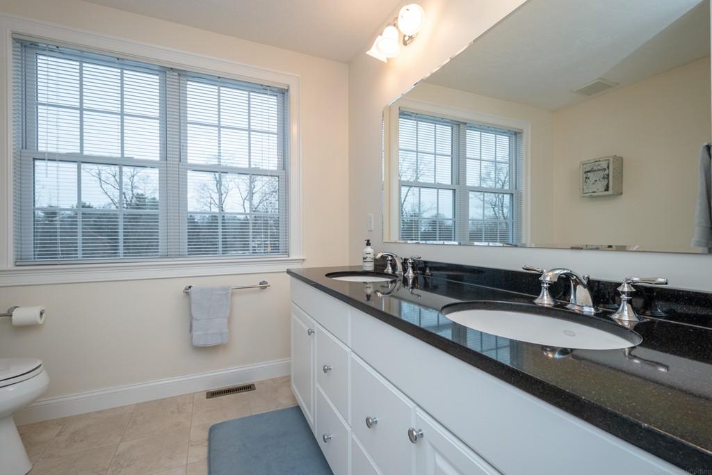 1094 Hill Road, Unit 1094 Boxborough, MA 01719 - Photo 32 of 38 a bathroom with a granite countertop sink mirror and a toilet