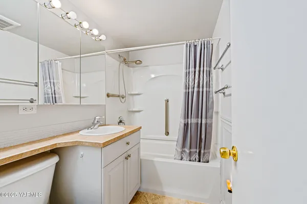 a bathroom with a sink vanity granite and a shower