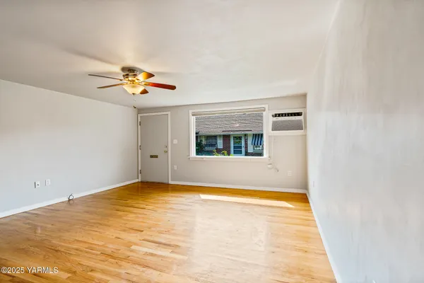 a view of empty room with wooden floor