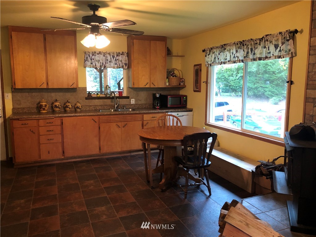 17706 Butler Road Snohomish, WA 98290 - Photo 5 of 22 a kitchen with stainless steel appliances granite countertop a stove a sink a dining table and chairs with wooden floor