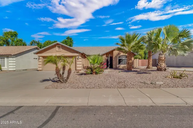 a view of a house with a yard and potted plants